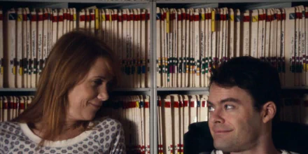 HD desktop wallpaper from The Skeleton Twins featuring a smiling woman and a man in front of a bookshelf.