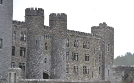 Man-made Ashford Castle stone façade and round towers under a pale sky — HD PC desktop wallpaper and background.