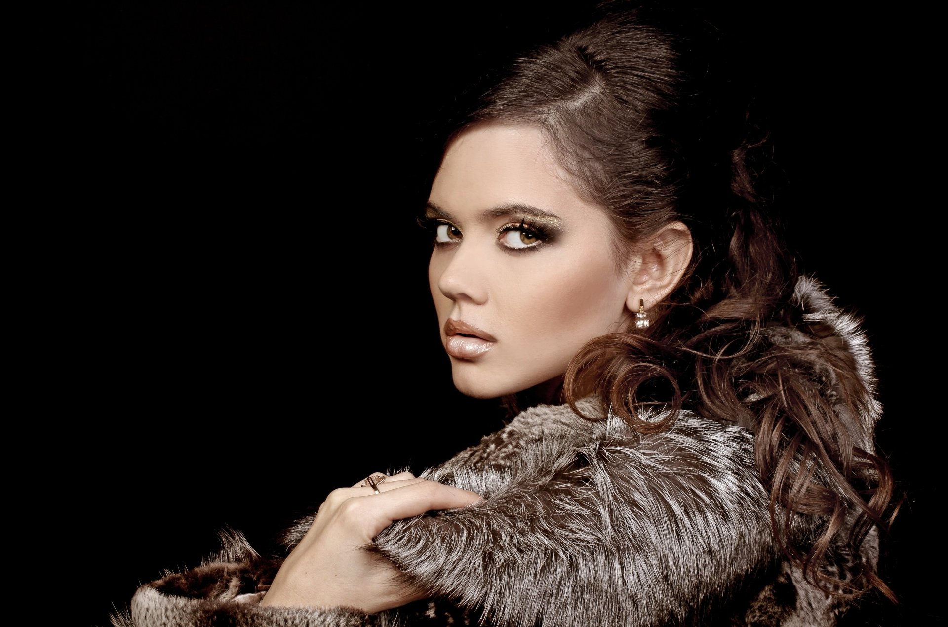 Close-up portrait of a woman's face and shoulders wrapped in a fur coat, dramatic lighting on a dark backdrop — 4K Ultra HD PC desktop wallpaper and background.