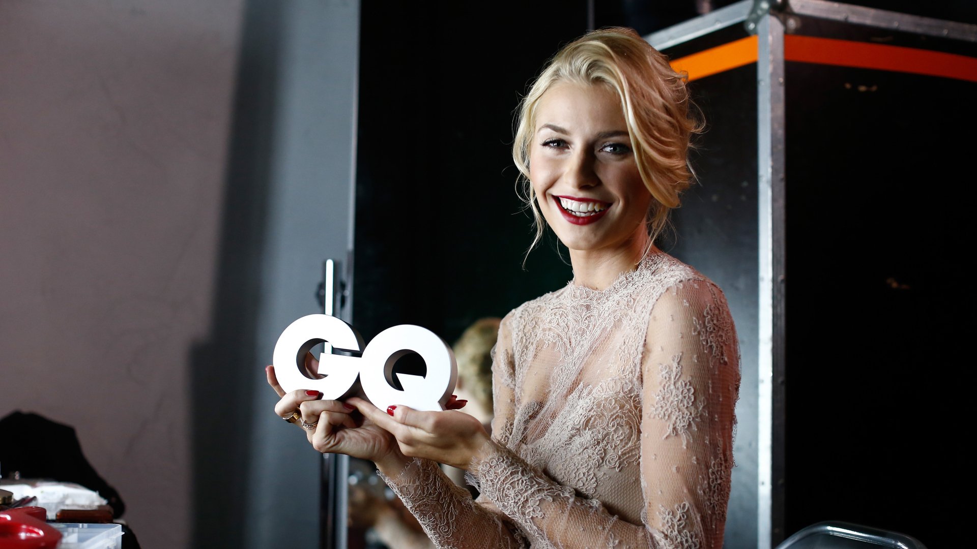 Smiling German model woman in a lace gown holds a GQ trophy backstage — 4K Ultra HD PC desktop wallpaper/background.