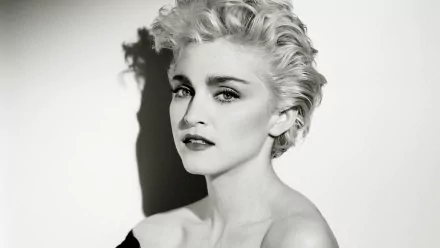 A black and white HD desktop wallpaper featuring Madonna, showcasing her striking features and iconic hairstyle against a contrasting background.