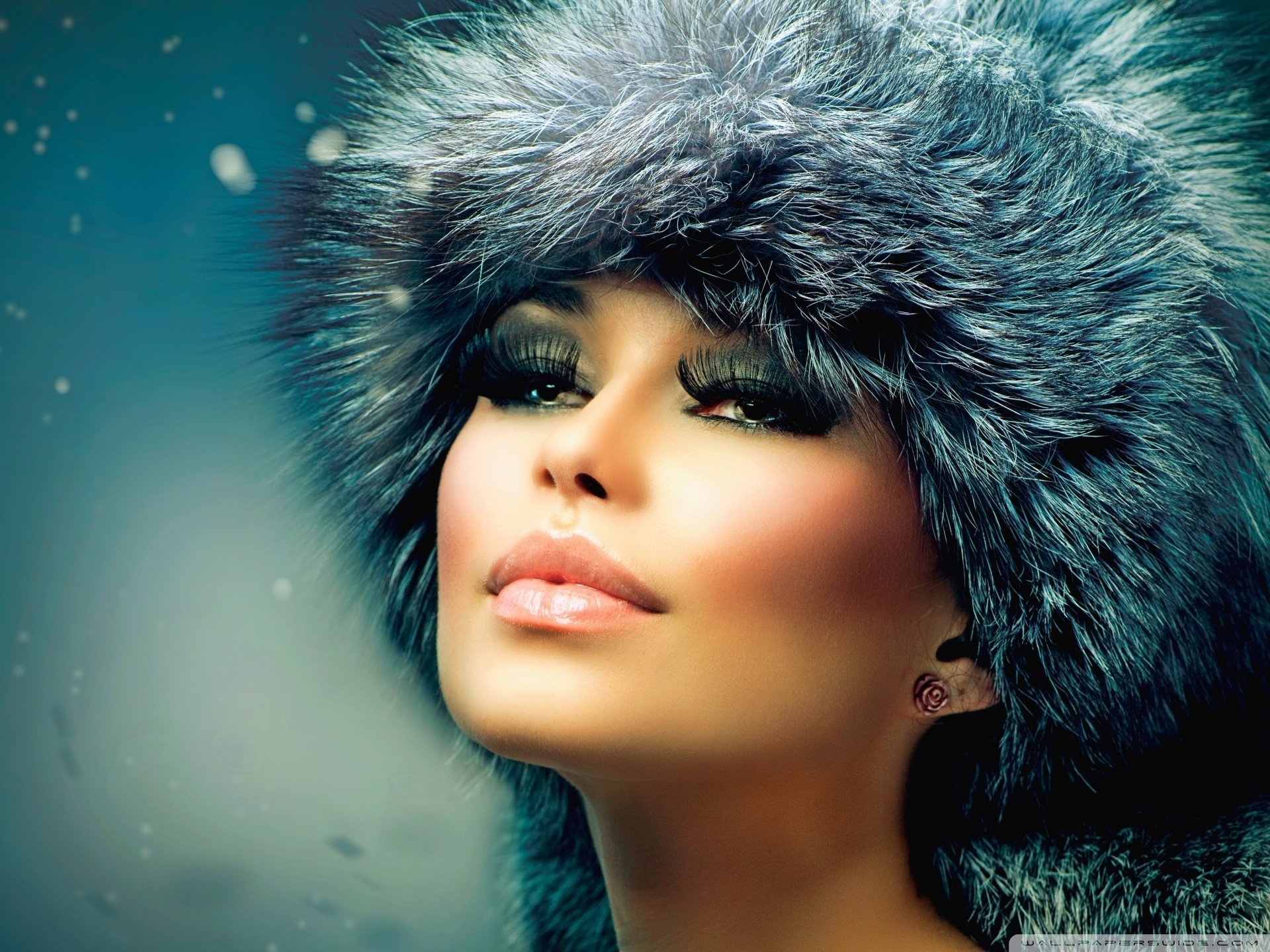 HD desktop wallpaper of a cute brunette woman wearing a fur hat, capturing a serene winter mood with a close-up on her face.