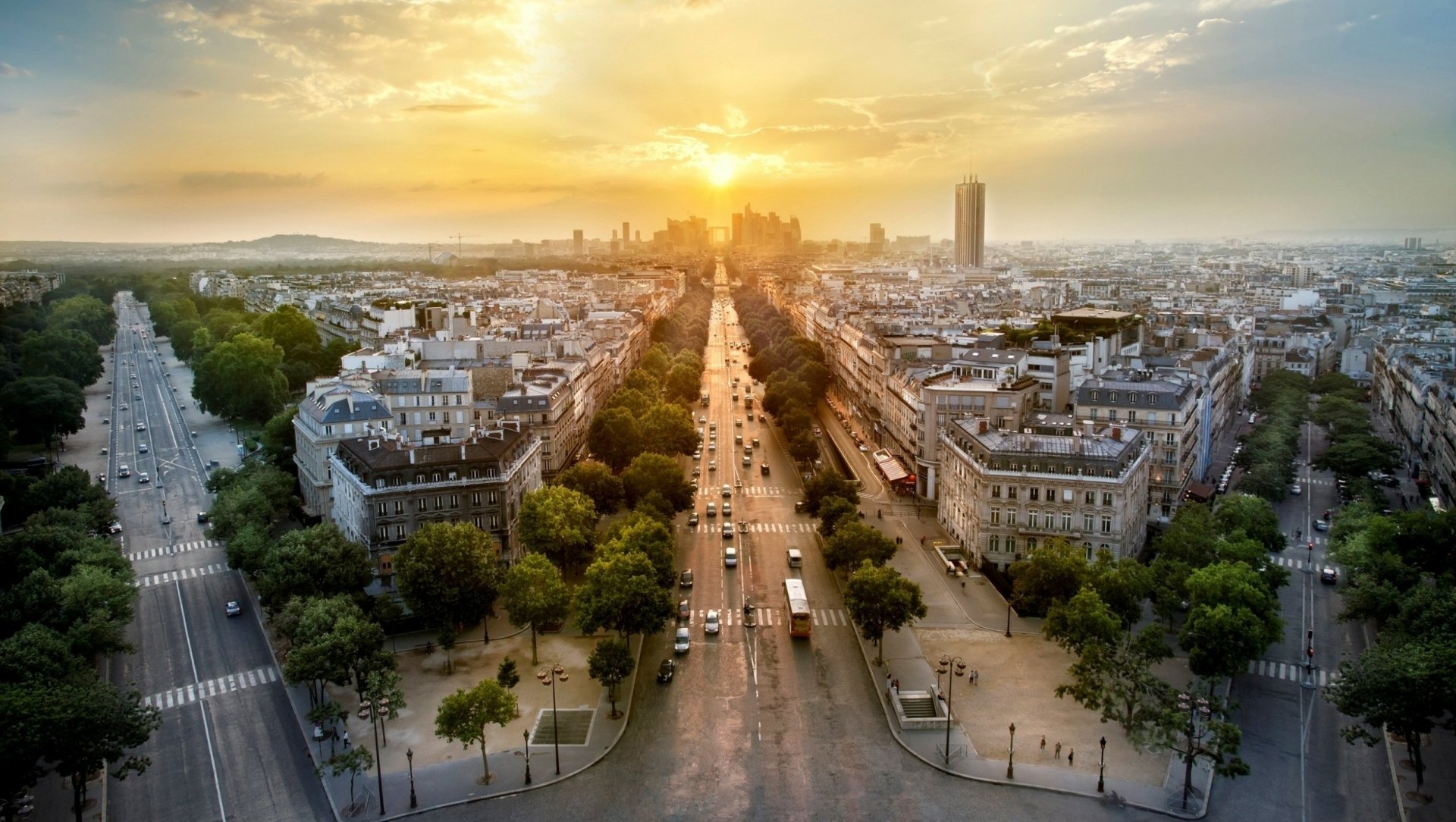 A stunning sunset over La Défense, Paris, showcasing a vibrant urban landscape with tree-lined avenues and modern architecture in a breathtaking HD wallpaper.