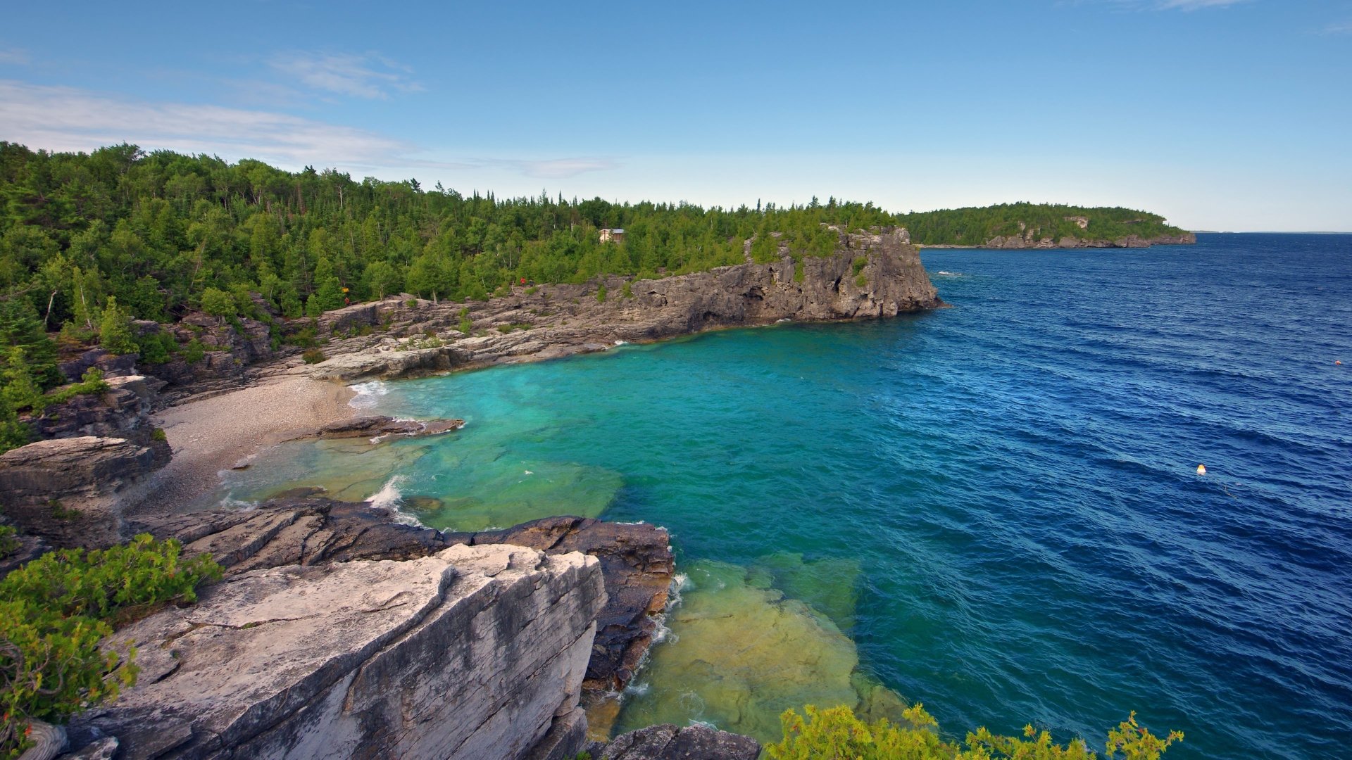 A stunning seascape showcasing a tranquil coastline with clear blue waters and lush greenery, captured in vibrant detail. An ideal 4K Ultra HD desktop wallpaper for nature lovers.