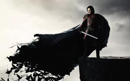 HD desktop wallpaper featuring the movie Dracula Untold. The image portrays Dracula, cloaked and holding a sword, standing on a cliff with bats flying in the background.
