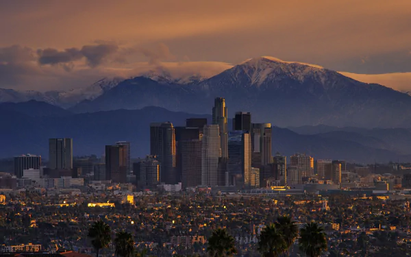 A stunning night view of Los Angeles, showcasing the city's skyline against a backdrop of mountains, with glowing lights illuminating the vibrant urban landscape.
