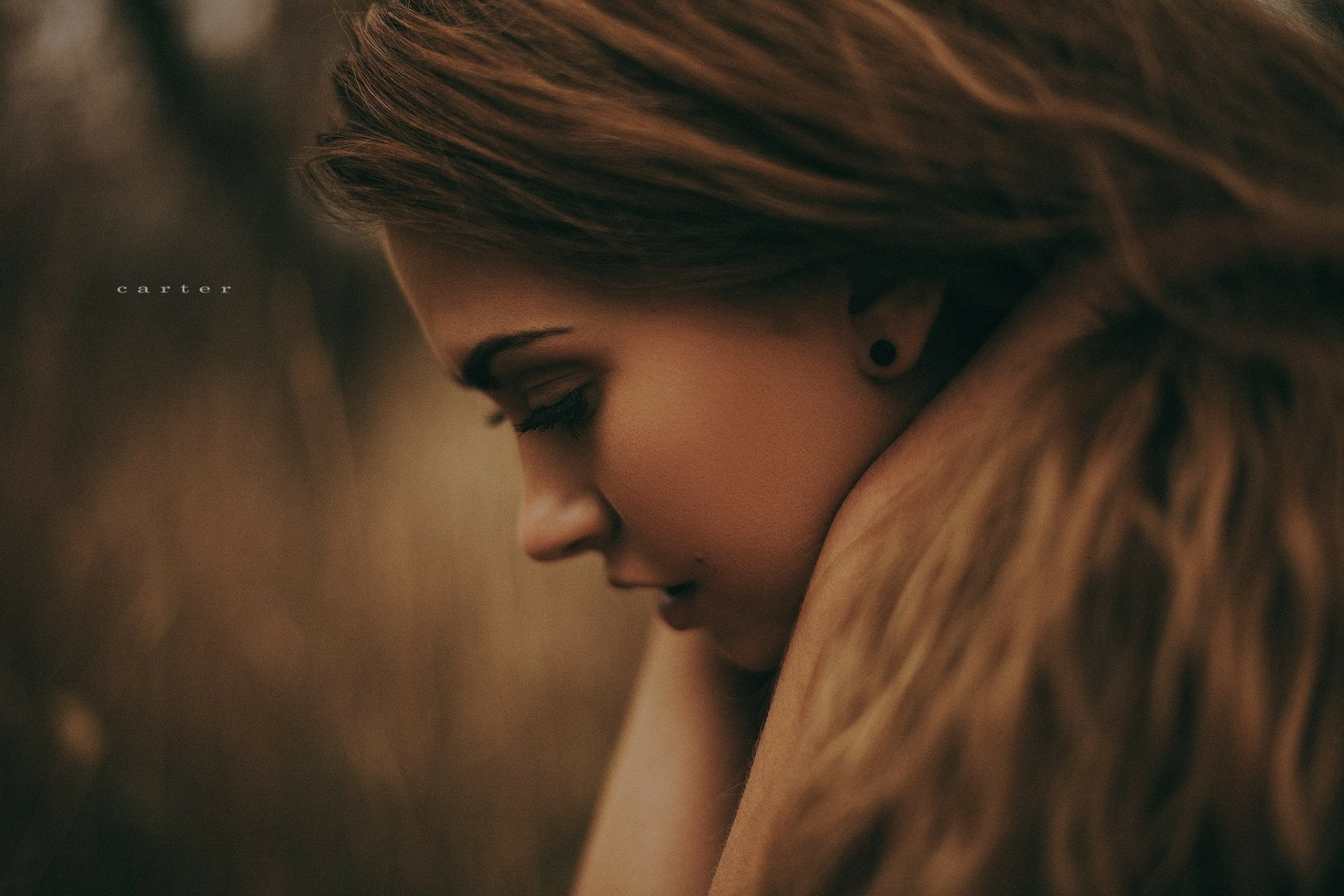 HD wallpaper featuring a woman's profile with a contemplative expression, set against a blurred, earthy background.