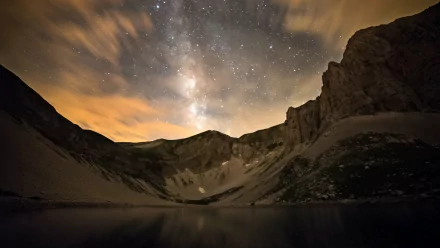 4K Ultra HD sci-fi desktop wallpaper showcasing the Milky Way arching over rugged mountain cliffs under a starry night sky.