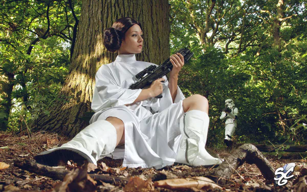 An HD desktop wallpaper featuring a woman cosplaying as Princess Leia from Star Wars, sitting in a forest with a blaster, while a stormtrooper stands in the background.