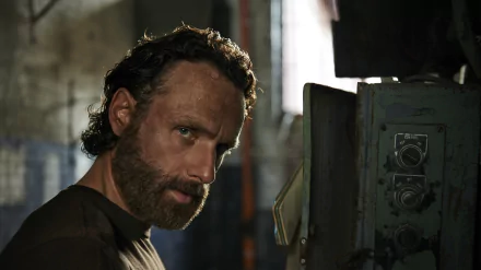 A close-up of Andrew Lincoln as Rick Grimes from The Walking Dead, featuring a rugged expression against a gritty background, captured in high-definition wallpaper format.