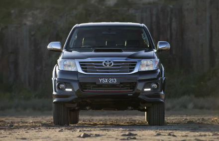 Front view of a black Toyota Hilux vehicle parked outdoors, featured as an HD PC desktop wallpaper and background.