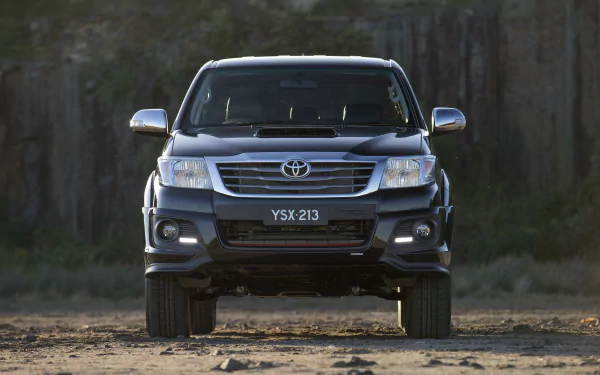 Front view of a black Toyota Hilux vehicle parked outdoors, featured as an HD PC desktop wallpaper and background.