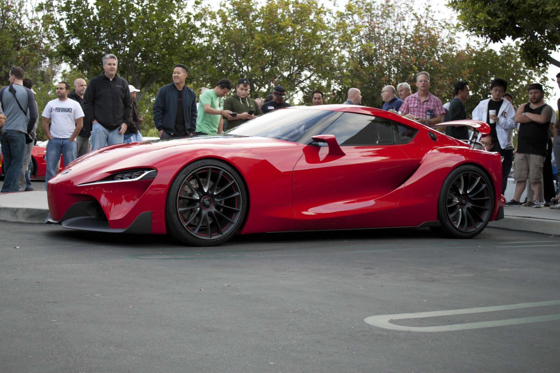 A red Toyota FT-1 concept supercar on display with spectators in the background, suitable as an HD desktop wallpaper.