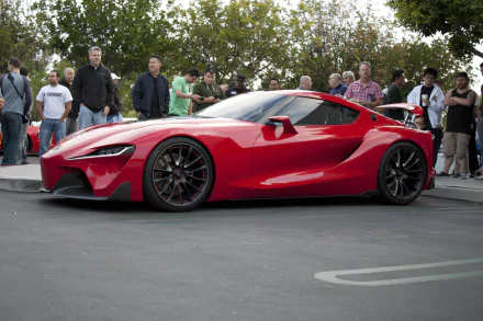 A red Toyota FT-1 concept supercar on display with spectators in the background, suitable as an HD desktop wallpaper.