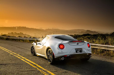 Silver Alfa Romeo 4C coupé parked on a city road at sunset, captured in a high-definition PC desktop wallpaper.