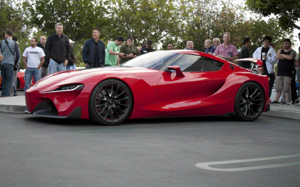 A red Toyota FT-1 concept supercar on display with spectators in the background, suitable as an HD desktop wallpaper.
