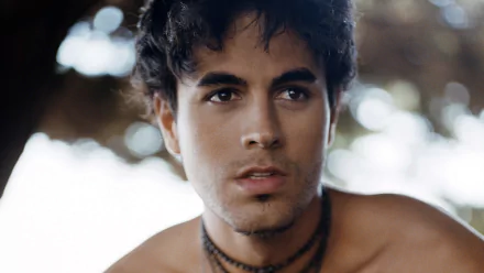 HD desktop wallpaper featuring Enrique Iglesias, capturing a close-up of the artist with a contemplative expression against a softly blurred background.