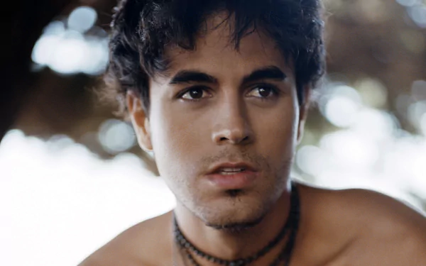 HD desktop wallpaper featuring Enrique Iglesias, capturing a close-up of the artist with a contemplative expression against a softly blurred background.