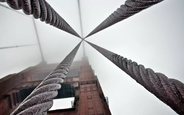 A 4K Ultra HD desktop wallpaper capturing the vertical perspective of the man-made Golden Gate Bridge cables and tower disappearing into fog.