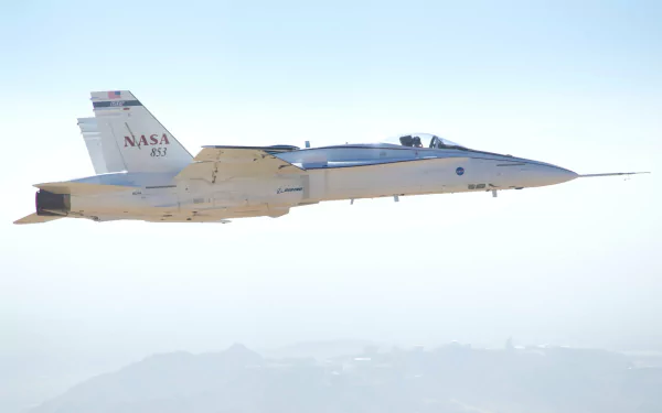 A NASA McDonnell Douglas F/A-18 Hornet military airplane flying against a clear sky in a 4K Ultra HD desktop wallpaper.
