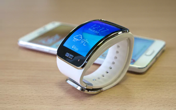 Samsung Galaxy smartwatch with two Galaxy phones on a wooden desk — technology-themed 4K Ultra HD PC desktop wallpaper.