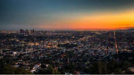 A breathtaking 4K Ultra HD view of Los Angeles at night, showcasing the vibrant city lights and skyline against a colorful sunset backdrop.