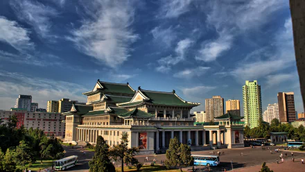 HD desktop wallpaper featuring a man-made architectural landmark in Pyongyang under a vibrant sky with surrounding urban buildings.
