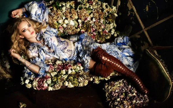 HD desktop wallpaper featuring blonde celebrity Amanda Seyfried as a model, surrounded by flowers in an artistic and elegant setting.
