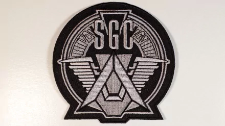 SGC emblem patch from TV show Stargate SG-1 on a white background, rendered as a 2K Quad HD PC desktop wallpaper and background.