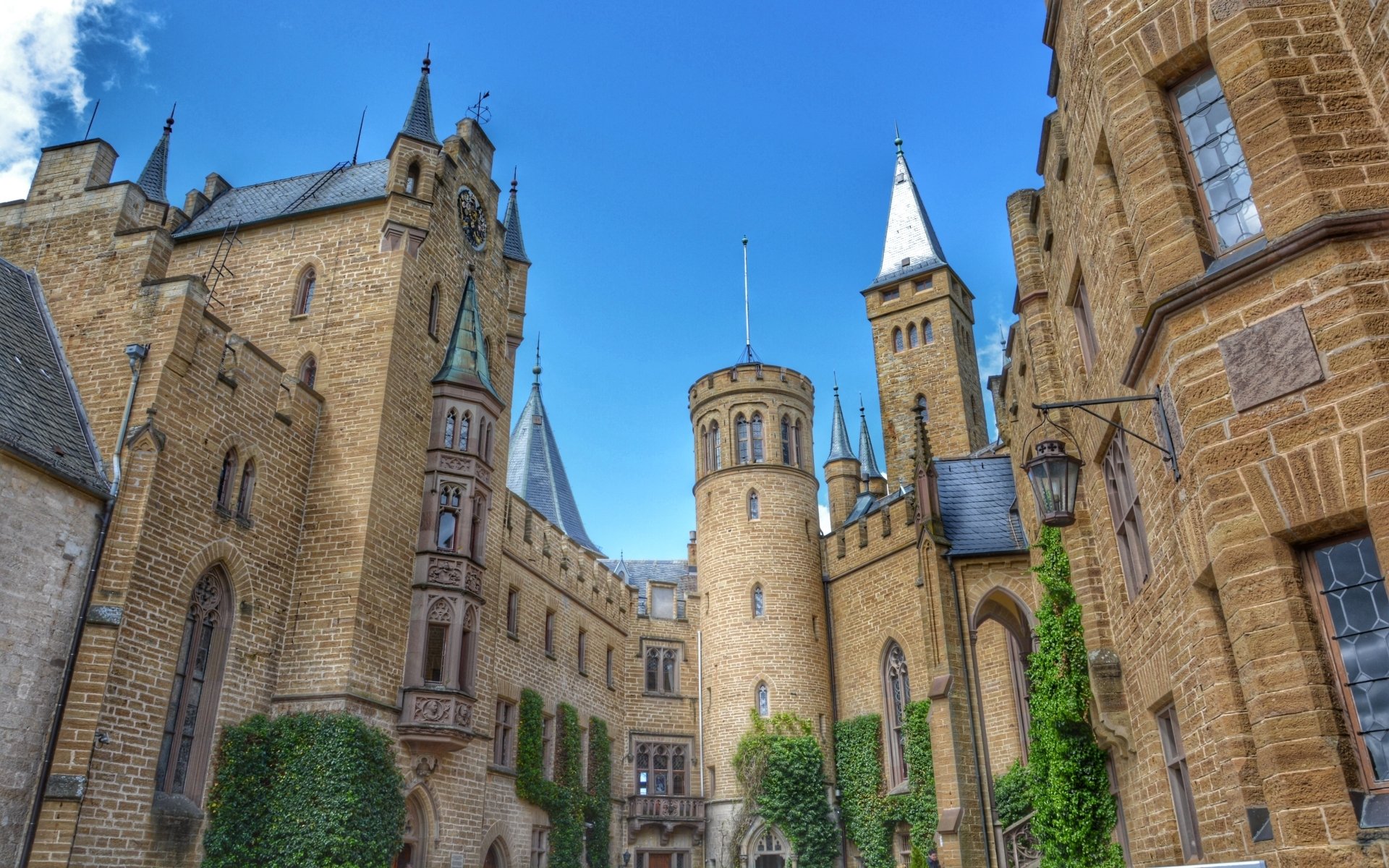 HD desktop wallpaper showing the man-made Hohenzollern Castle with its towering stone walls and turrets under a clear blue sky.