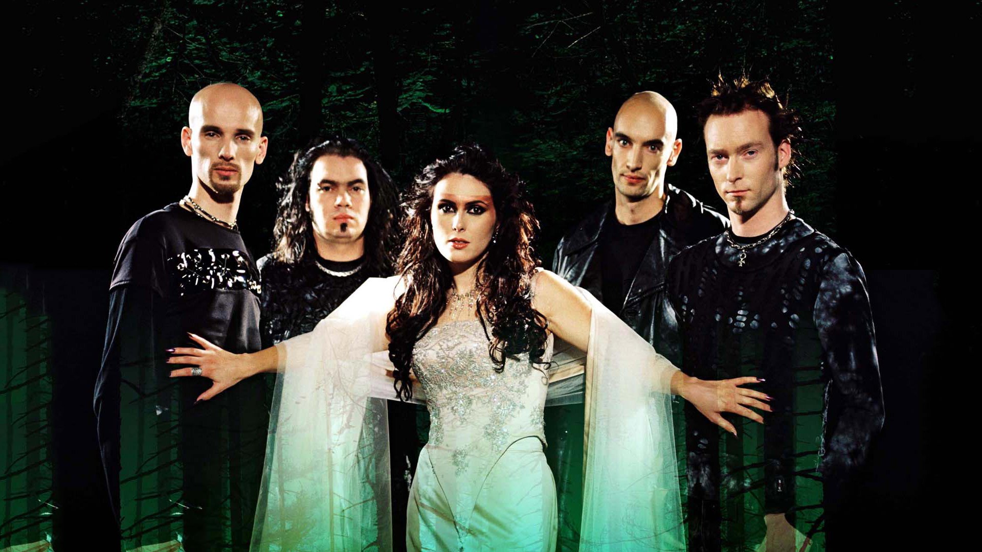 HD desktop wallpaper featuring the symphonic metal band Within Temptation standing in a dark, forested background, highlighting their dramatic and gothic style.