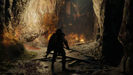 HD PC desktop wallpaper: Talion (Middle-earth) from the video game Middle-earth: Shadow of Mordor — silhouetted with sword and cloak at a cave entrance facing a burning interior.