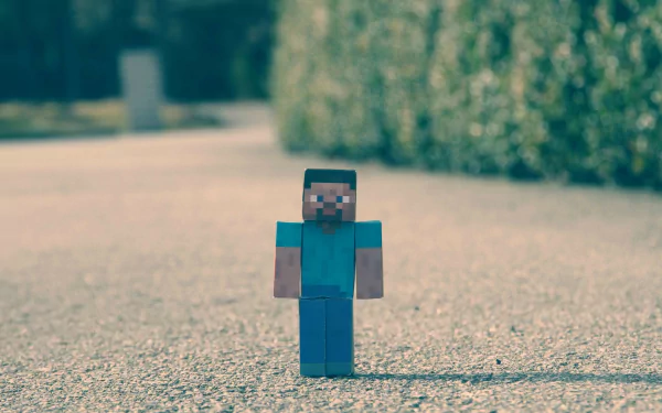 HD desktop wallpaper featuring Steve from Minecraft, a popular video game created by Mojang, standing on a gravel path with green foliage in the background.