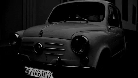 A dark, moody HD wallpaper of a classic Zastava 750 old car, parked in Belgrade, Serbia, showcasing vintage automotive design.