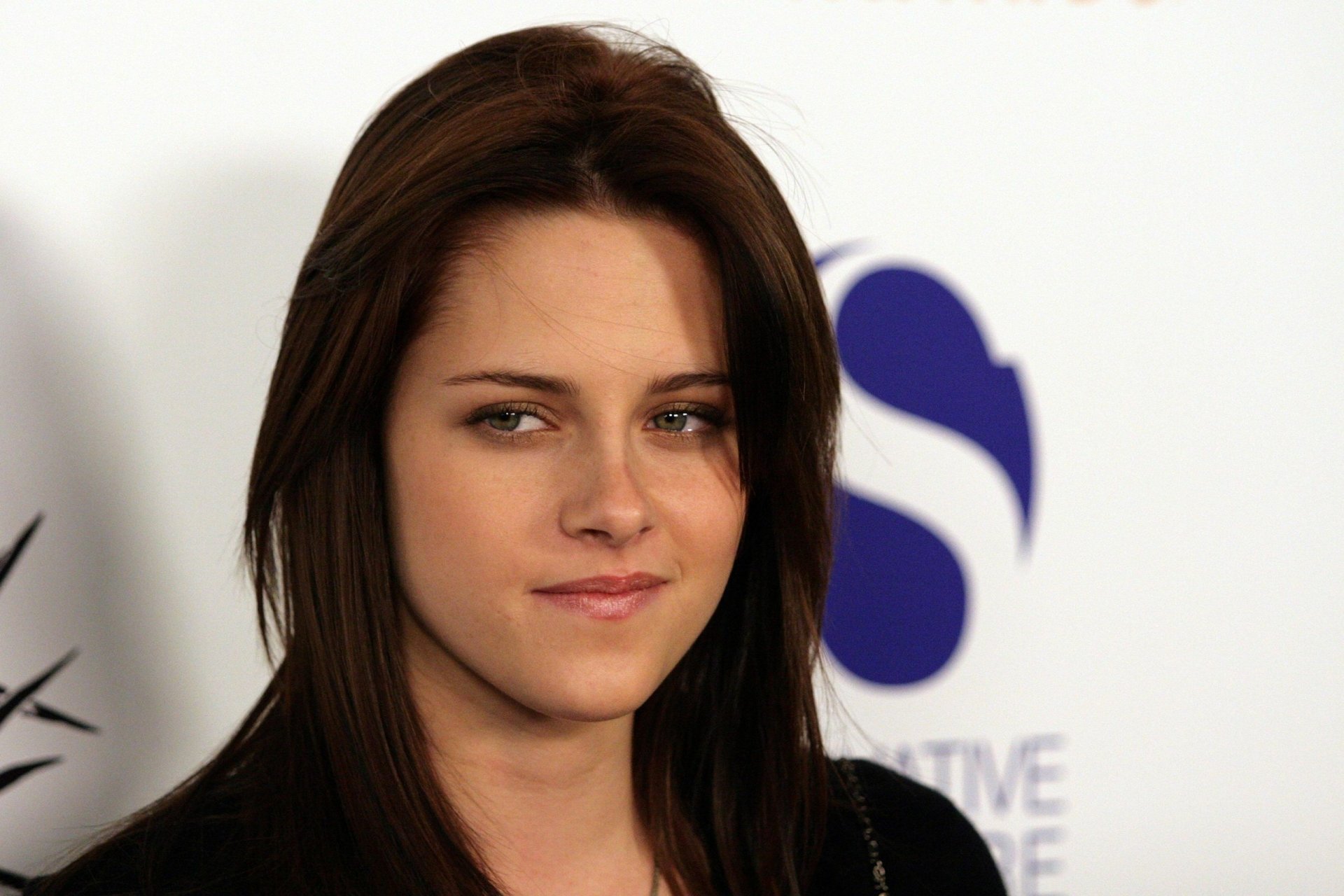 A high-definition desktop wallpaper featuring a close-up of Kristen Stewart, showcasing her confident expression against a softly blurred background.