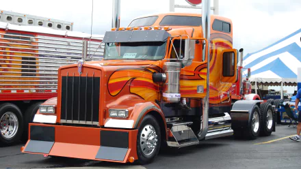 A vibrant orange Kenworth truck with flame decals, captured in sharp detail for a 4K Ultra HD PC desktop wallpaper and background.