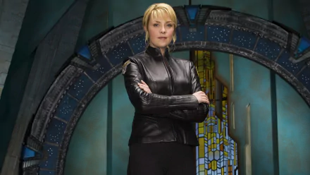 Samantha Carter, portrayed by Amanda Tapping, stands confidently in front of a Stargate, showcasing her role from the TV show Stargate Atlantis in this HD wallpaper.