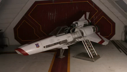 Battlestar Galactica (2003) Viper starfighter parked in a hangar, open cockpit and boarding ladder extended — 2K Quad HD PC desktop wallpaper/background.