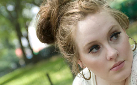 Adele, the talented British singer, is captured in a serene outdoor setting, showcasing her expressive features in this HD wallpaper and background.