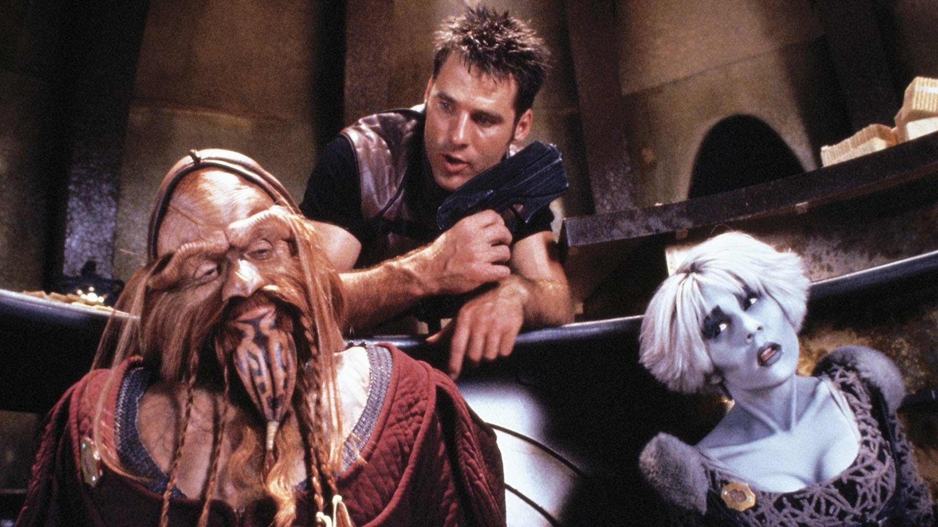 HD PC desktop wallpaper of a scene from the TV show Farscape: a man with a blaster leans over a tentacled alien and a pale blue-skinned woman inside a dim spacecraft interior.
