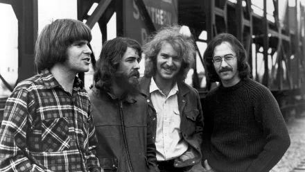 Black-and-white HD desktop wallpaper of the rock band Creedence Clearwater Revival posing outdoors near a bridge or industrial structure.
