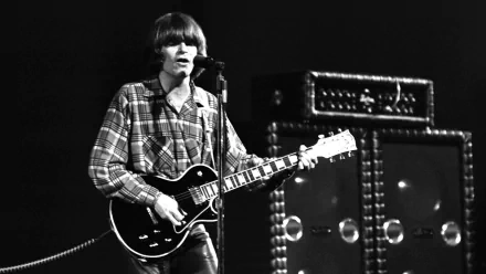 Black and white HD desktop wallpaper showing a Creedence Clearwater Revival musician playing guitar and singing on stage.