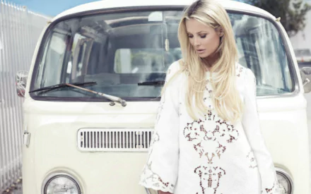 Blonde model in a white embroidered swimwear cover-up posing by a vintage cream van — 2K Quad HD PC desktop wallpaper/background.