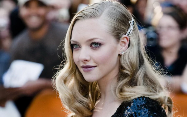 HD PC desktop wallpaper featuring a close-up of celebrity Amanda Seyfried with styled blonde hair and a subtle smile at a red carpet event.
