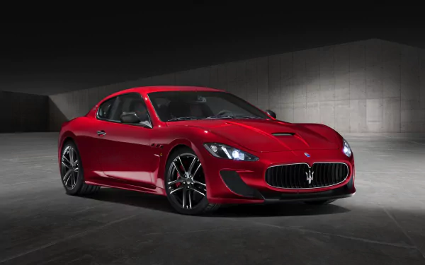 Sleek red Maserati GranTurismo showcased in a modern concrete setting, captured in 4K Ultra HD for a striking PC desktop wallpaper.