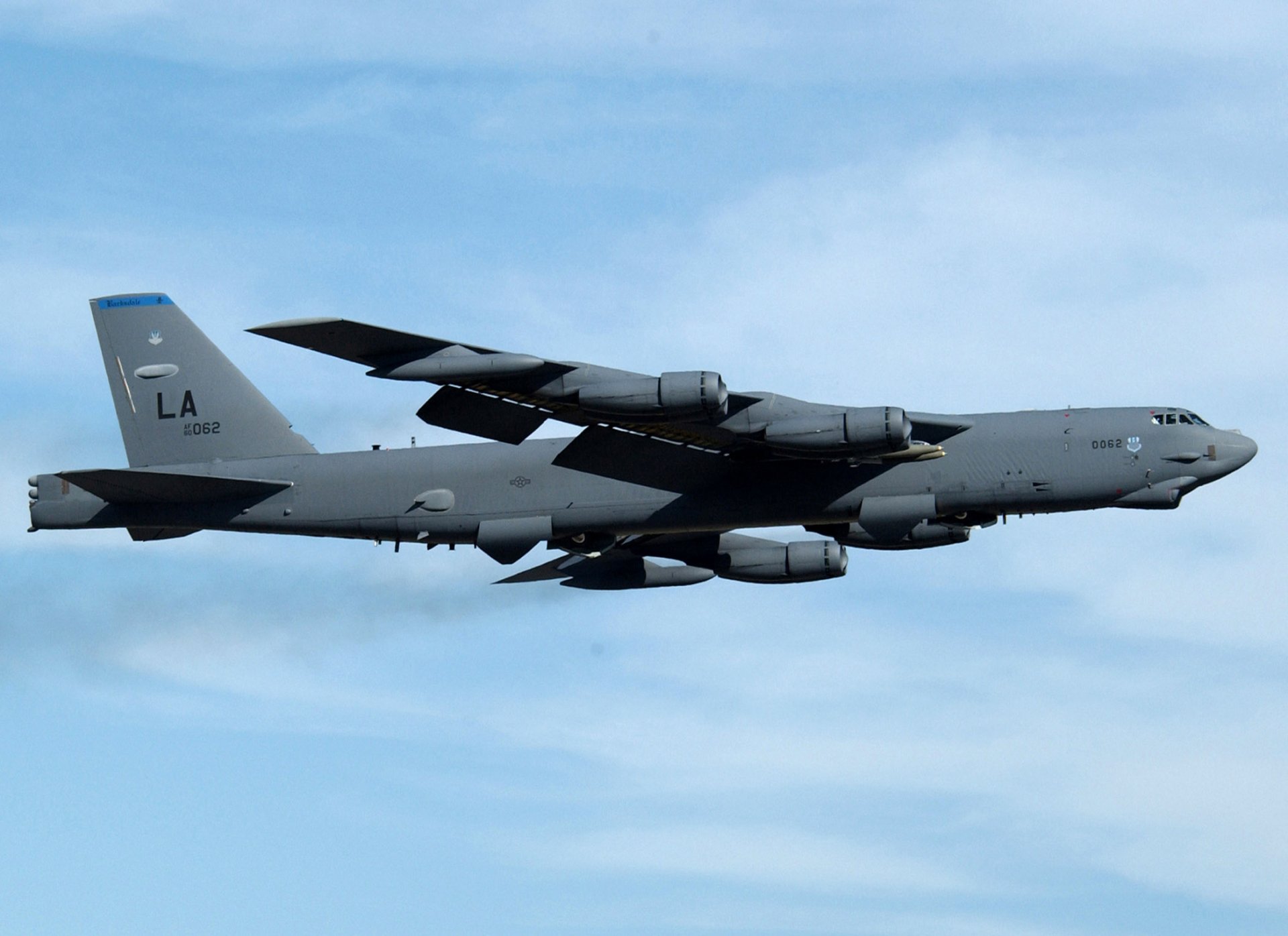 A Boeing B-52 Stratofortress flying against a clear sky, showcasing its military design. This high-definition image serves as an impressive desktop wallpaper.