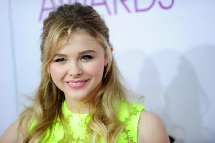 Chloë Grace Moretz smiles warmly, showcasing her vibrant style in this 4K Ultra HD desktop wallpaper, capturing her youthful charm and star power.