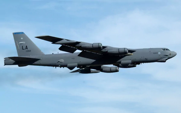 A Boeing B-52 Stratofortress flying against a clear sky, showcasing its military design. This high-definition image serves as an impressive desktop wallpaper.