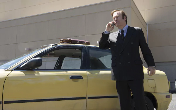 HD wallpaper of Bob Odenkirk as Jimmy McGill from Better Call Saul, standing by a yellow car, talking on a cell phone.