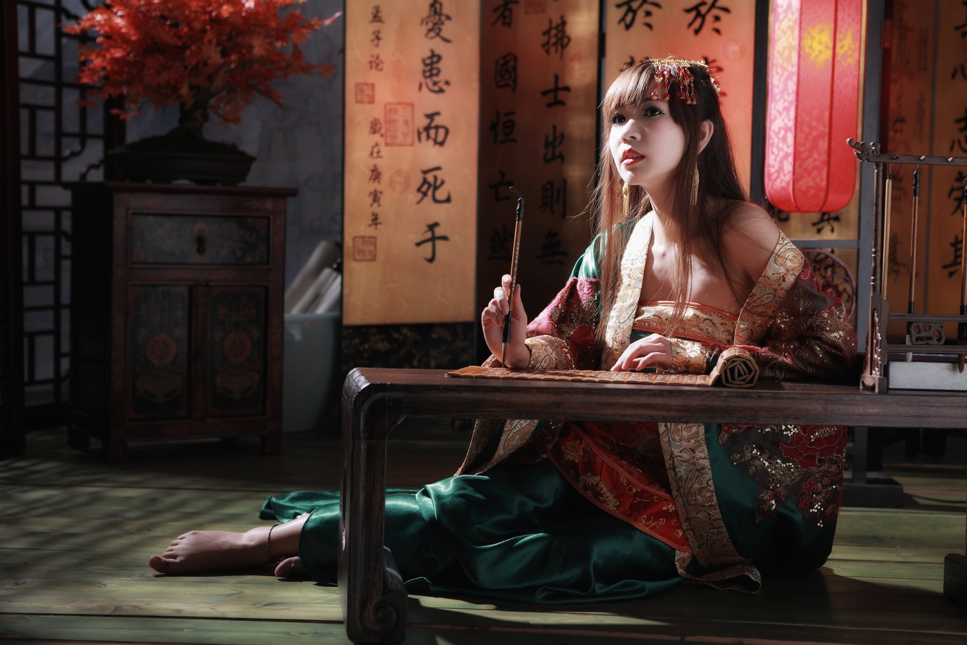 A woman in traditional Taiwanese dress sits gracefully beside calligraphy scrolls and a bonsai, embodying cultural elegance in this vibrant 4K Ultra HD wallpaper.